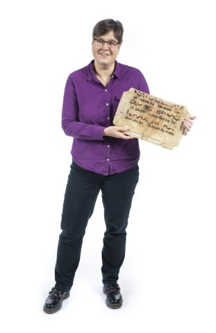 Johanna Kramer holding a medieval manuscript page