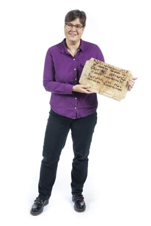 Johanna Kramer holding a medieval manuscript page